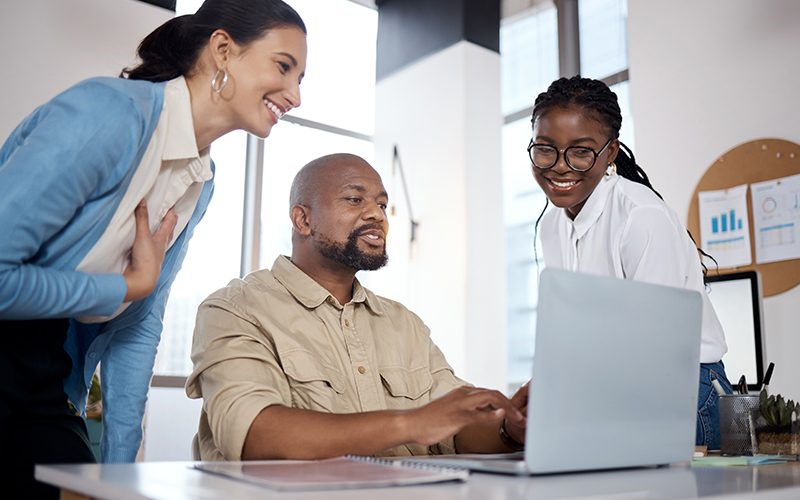 Depict a school IT support team helping teachers onboard to a new LMS. Show friendly interface screens, in-app tutorials, and local support available via chat or call. Highlight user ease and accessibility.
