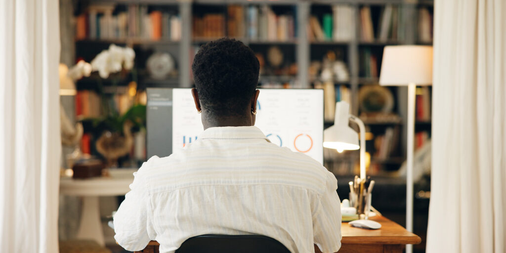 Remote worker viewing data charts on a desktop monitor, highlighting how LMS for employee training enables online learning from home.