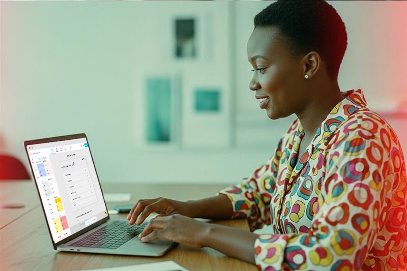Employee working on a laptop to manage courses inside a learning management system (LMS)
