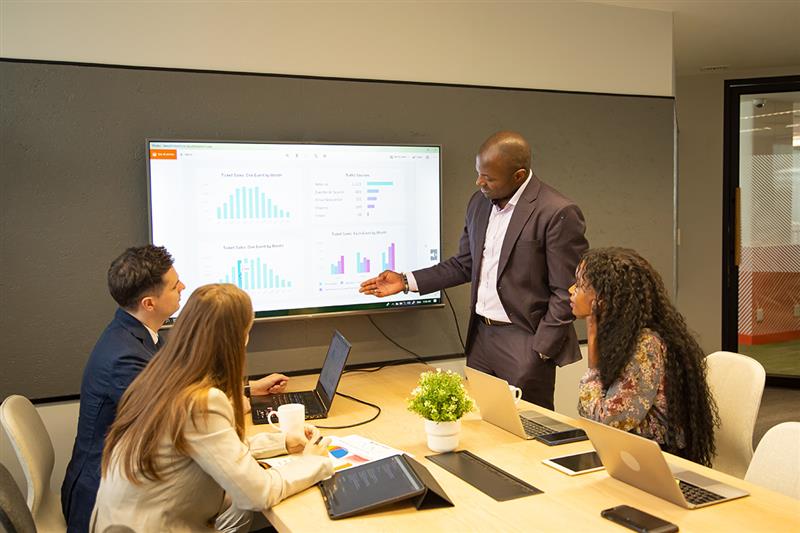 Business team discussing training data on a learning management system (LMS) dashboard during a meeting
