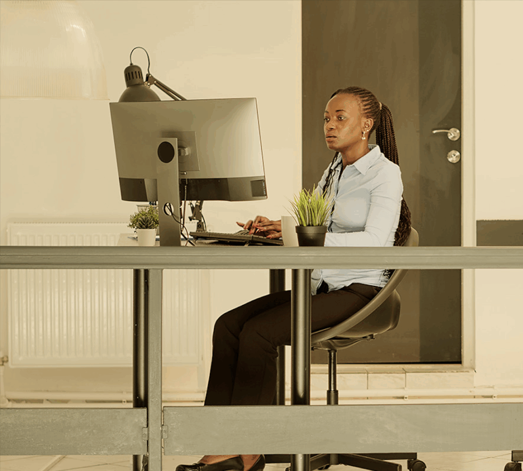 Modern office setup with employee using desktop computer powered by Cloud-based solutions.