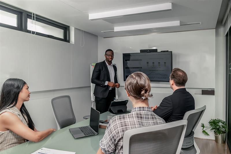 An edtech professional presenting data insights to a team in a meeting room, emphasizing transparency and the ethical use of data in edtech for decision-making.