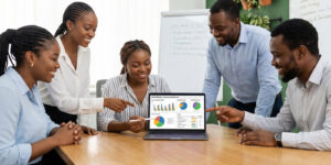 Corporate HR team reviewing employee training dashboard on laptop showing training courses, completion progress, and certification status, modern workplace learning environment