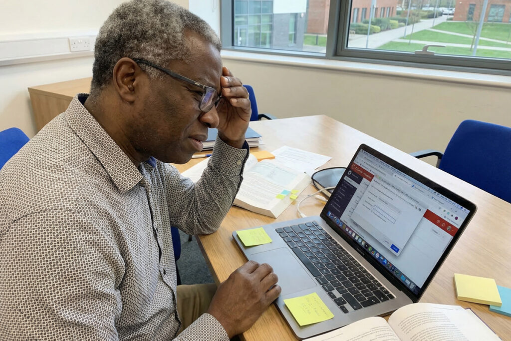 faculty training for online teaching University lecturer looking confused while navigating LMS interface on laptop, multiple tabs open, difficulty understanding digital tools visible